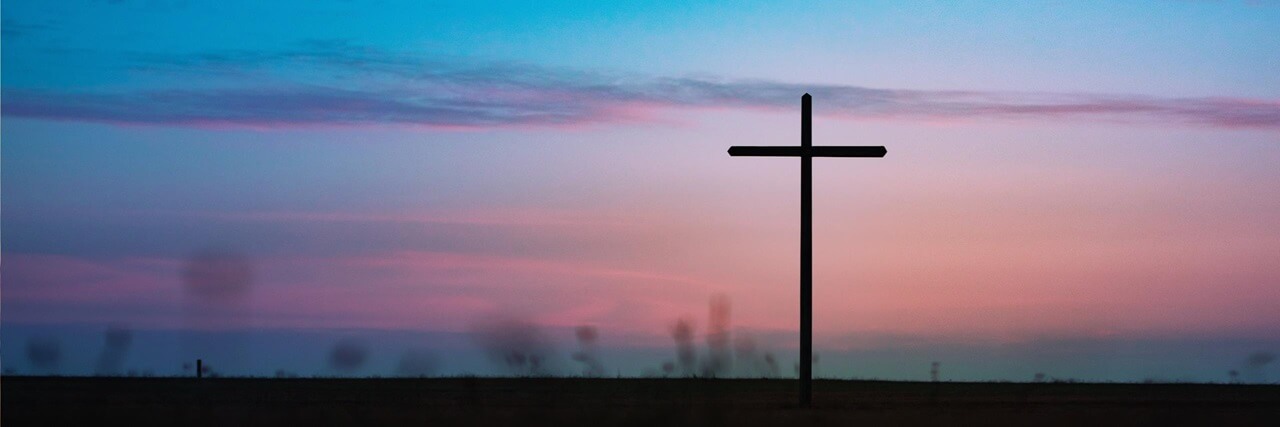 A cross with the sunset in the background